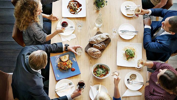 Personen am Tisch beim Mittagessen