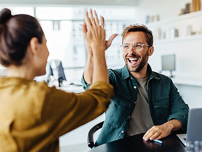 2 Personen geben sich ein High-Five