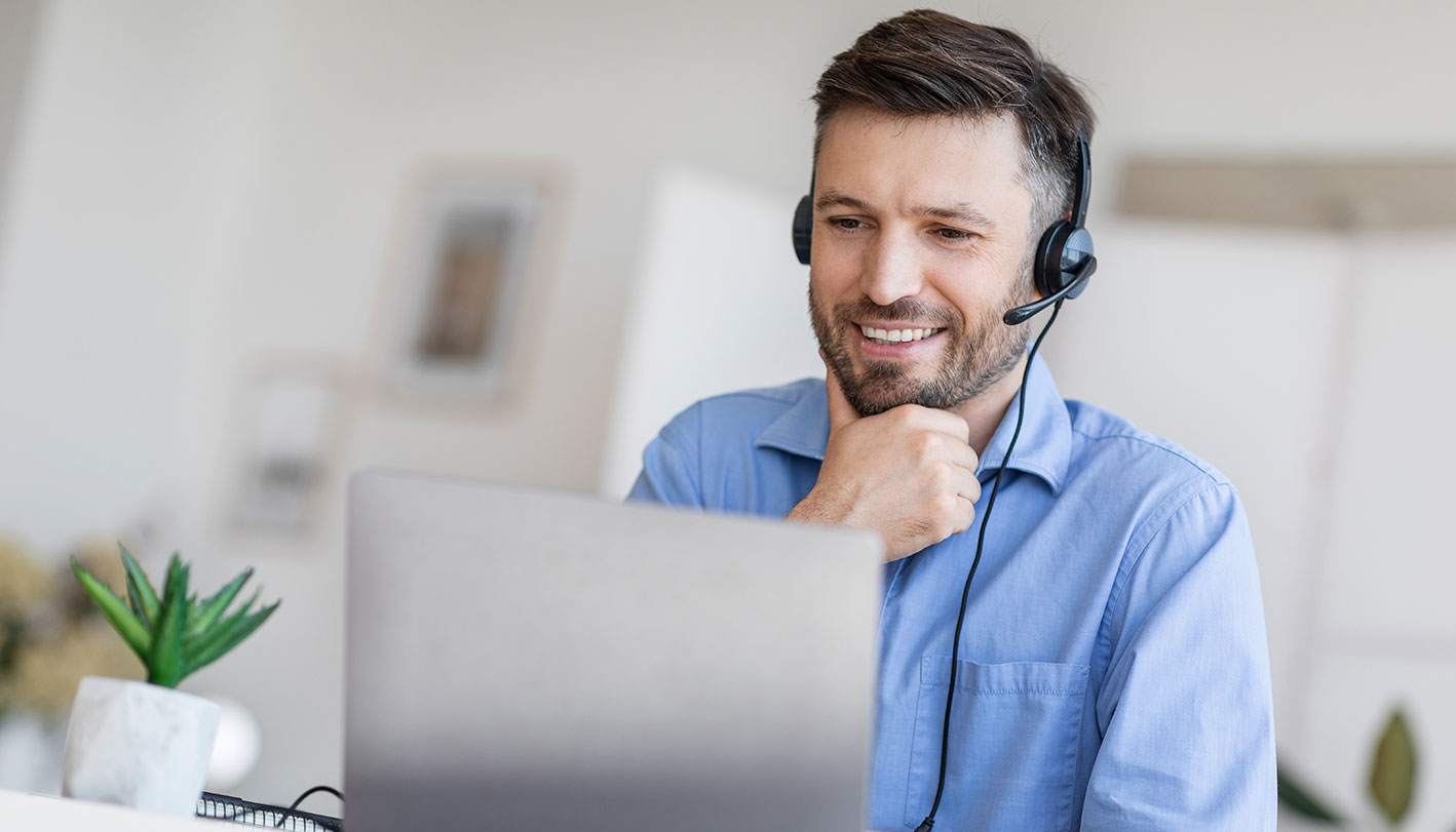 Mann mit Headset hält eine Videokonferenz