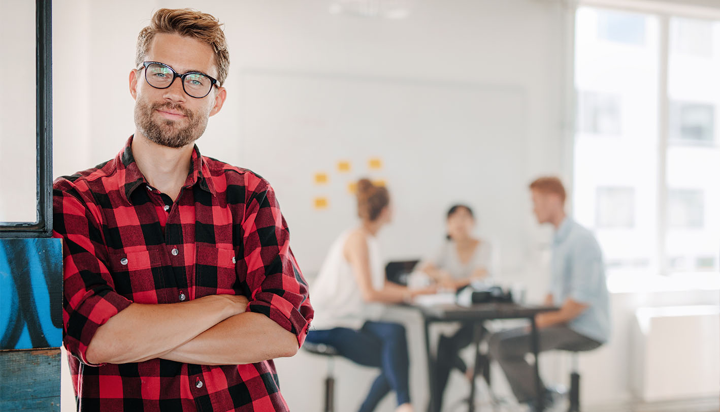 Mann im Büro, Gruppenarbeit im Hintergrund Mann im Büro, Gruppenarbeit im Hintergrund