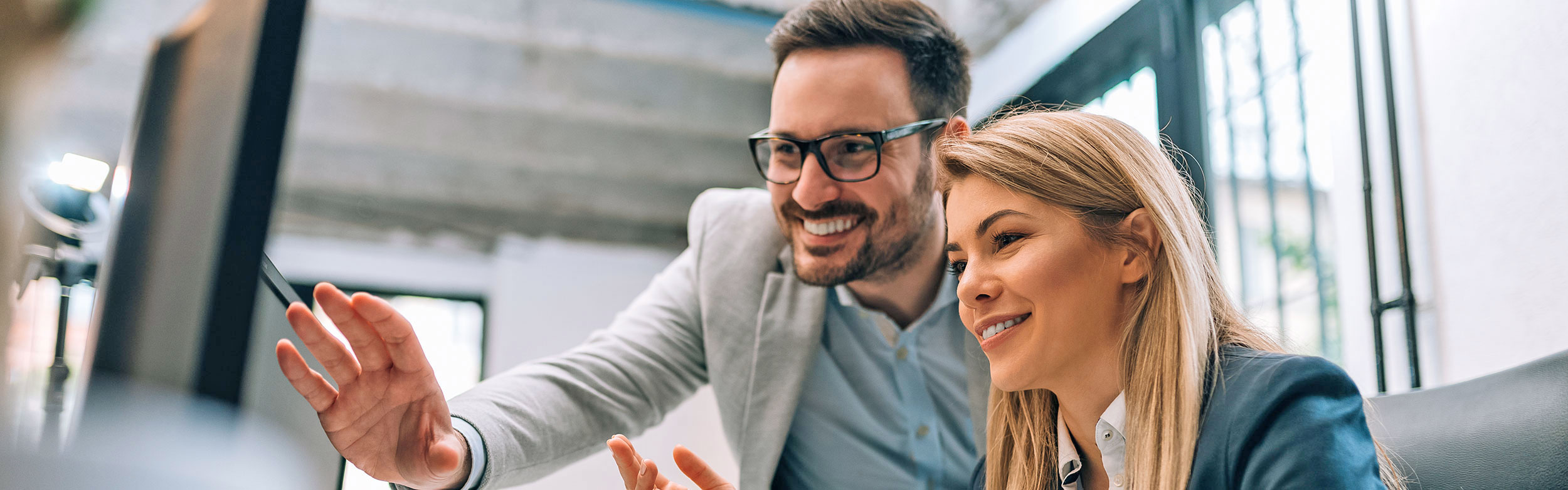 Frau und Mann besprechen etwas am PC