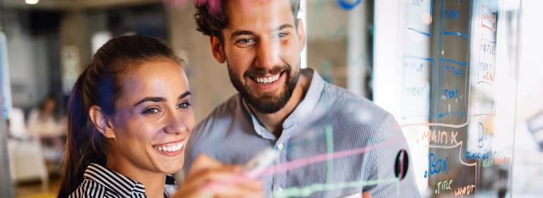 due persone davanti a una lavagna interattiva