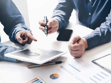 ein Team analysiert Unternehmenszahlen am Tablet