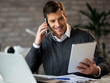 Mann mit Tablet telefoniert